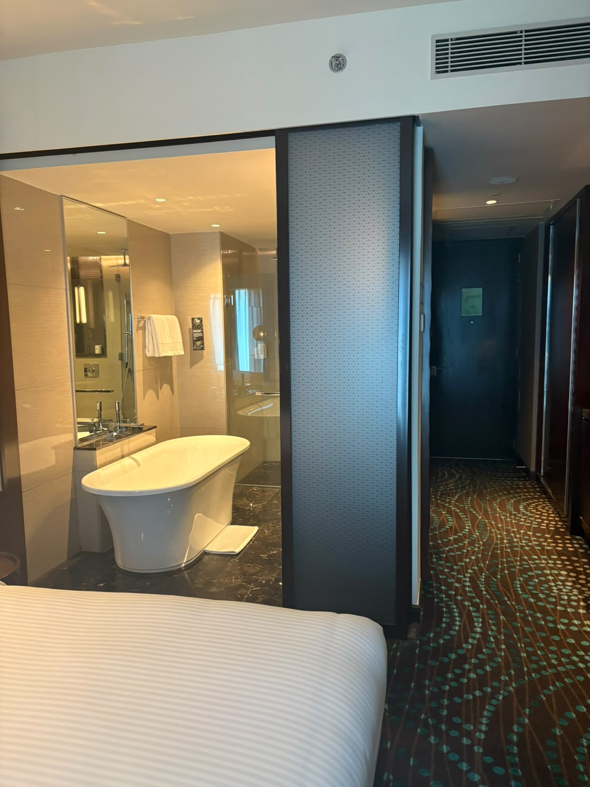 Luxury hotel suite with freestanding bathtub and marble floors at Taj Gurgaon
