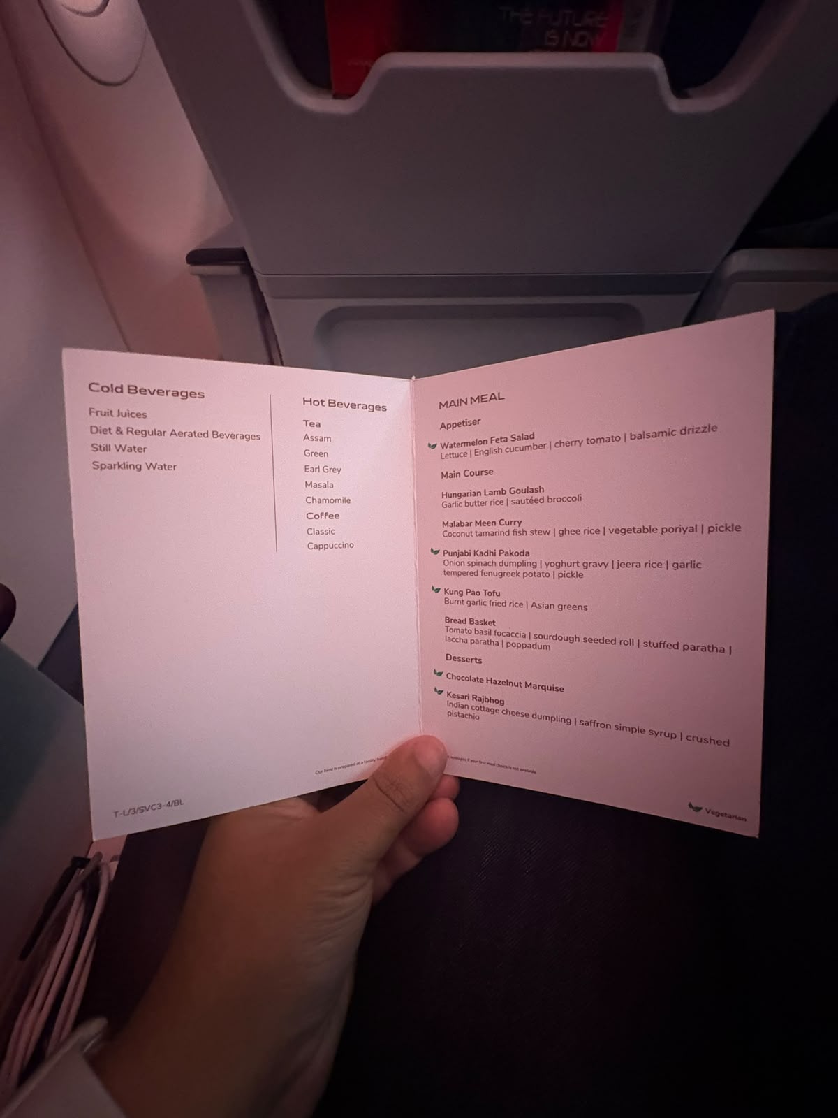 Business class inflight main meal menu held open in the cabin